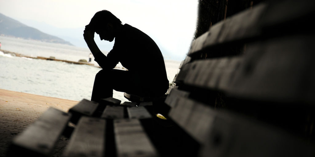 depressed young man sitting on the bench
